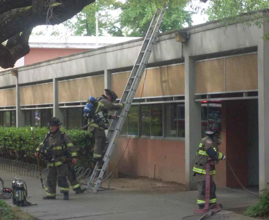 Firefighters used a portable ladder to get up and down from the roof of Acker Gym, where the mechanical fire took place. Photo credit: Angelo Boscacci