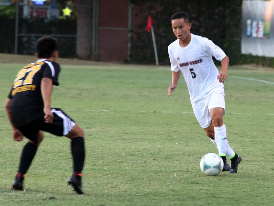 Chico State mens soccer player Patrick Lee approaches a defender in a game earlier this season.