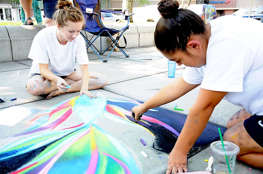 Butte College students Kelsey Wade, left, and Daryll Venegas, right, enjoy their 5th and 4th years at the Pastels on the Plaza event on Saturday from 9 a.m. to 2 p.m. at the Chico City Plaza. Photo credit: Annie Paige
