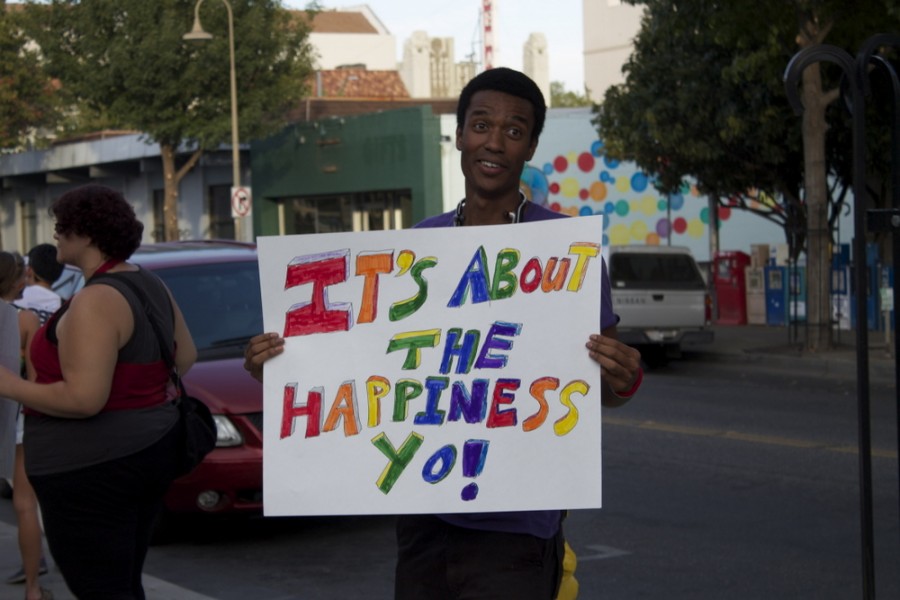 Participants in the Pride March had signs about happiness and love. 