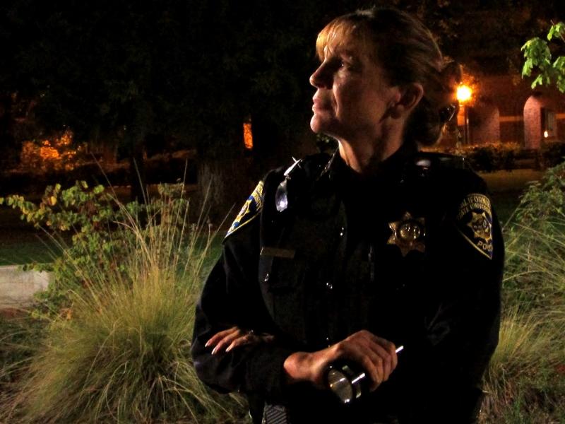 Police Chief Robyn Hearne examines the outside of the Performing Arts Center for broken light fixtures during the 10th annual Moonlight Safety Walk. Photo credit: Ashiah Scharaga