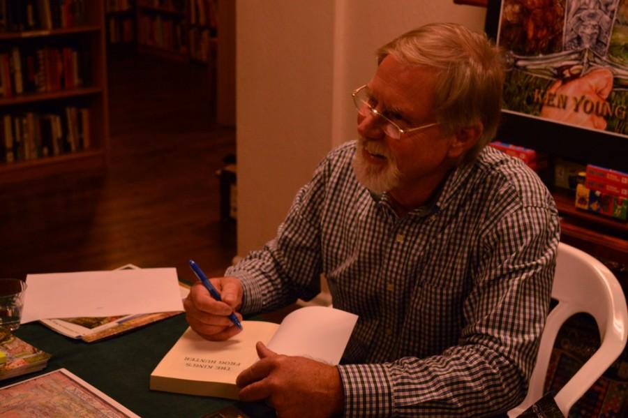 Paradise author Ken Young signs a copy of his first novel for a fan at the books presentation Tuesday at Lyon Books. Photo credit: Veronica Hodur