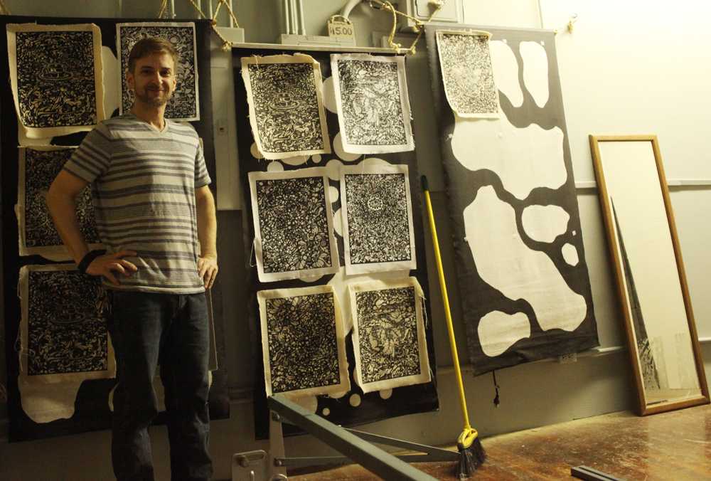 Brent Clark stands with some of his prints at The Orange Street Gallery. Photo credit: John Domogma