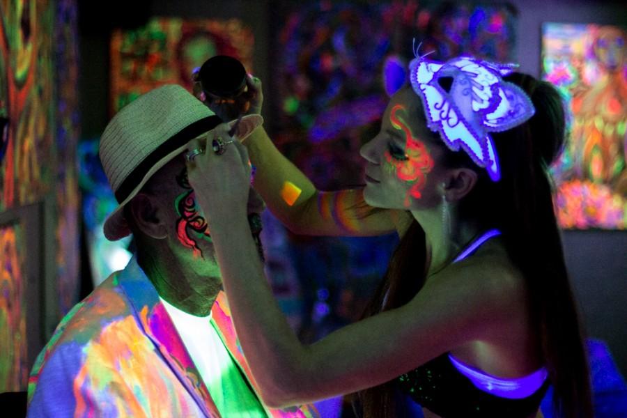 Body painter paints an artist's face.