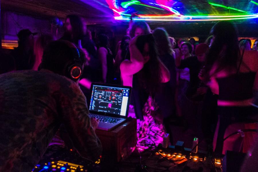 DJ on a computer while others dance