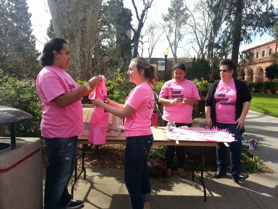 Mario Morales gives Ariel Kittredge, a junior at Chico State, her free shirt she won during the raffle outside of Kendall Hall. Photo credit: Brittany Mcclintock