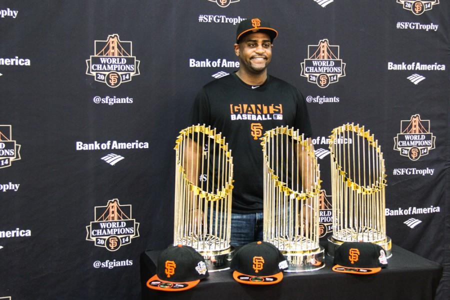 Joseph Gebreyesus gets his picture taken with the SF Giant's three World Series trophies on Saturday, Jan. 31, 2015 at the Arron Ray Clark Memorial Field House. Photo credit: Trevor Ryan