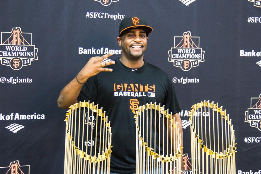 Joseph Gebreyesus gets his picture taken with the SF Giant's three World Series trophies on Saturday, Jan. 31, 2015 at the Arron Ray Clark Memorial Field House. Photo credit: Trevor Ryan