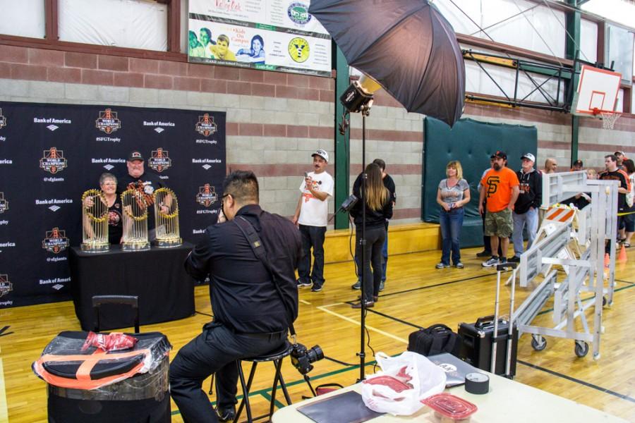 A couple get their picture gets his picture taken with the SF Giant's three World Series trophies while hundreds of Butte County residents wait behind them. The trophies were on display Saturday, Jan. 31, 2015 at the Arron Ray Clark Memorial Field House in Chico. Photo credit: Trevor Ryan