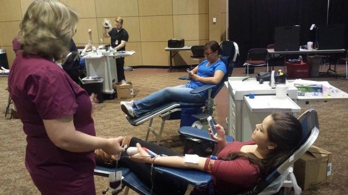 Chico State freshman Ana Perez, front, and sophomore Katherine Grote, back, wait while having blood drawn by Blood Source nurse Laurie Rothe at Mondays blood drive in the BMU Auditorium. Photo credit: Austin Redfern