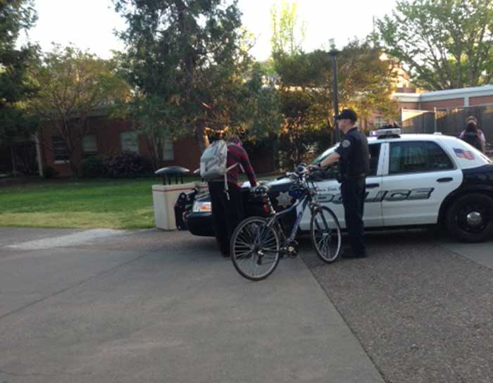 A University Police officer gives a student a ticket for riding his bike within Chico States campus core area. Photo credit: Michael Arias