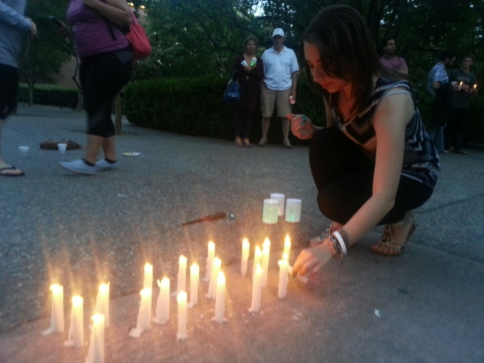 Chico State third year Sylvia Dorghalli places her candle to spell out Nepal outside of Siskiyou Hall