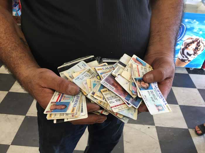 Addel Mubraaka, owner of Tonys Liquor, collects Fake IDs that students have used to try to purchase alcohol. Photo credit: Suzy Leamon