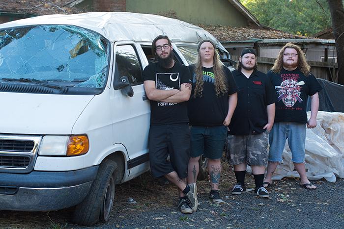 Members of the band, Aberrance, (from left) Ed Vance, Jake Hollingsworth, David Hordienko, and Nick Rahming hang out with their retired tour van on Tuesday. Photo credit: Alicia Brogden