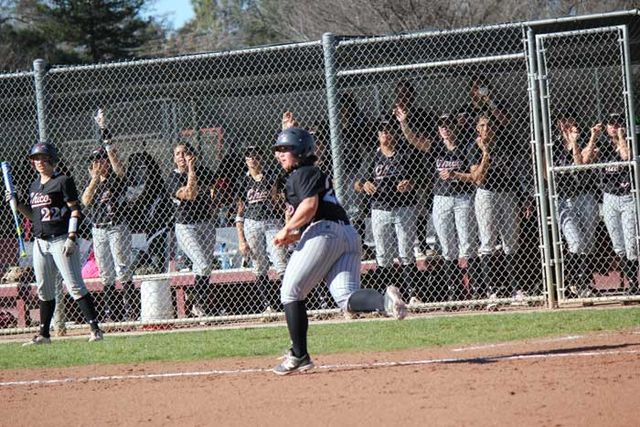 Junior Cyrena Taylor runs to first base as her team cheers her on during the game against Dominican University on Feb. 7.