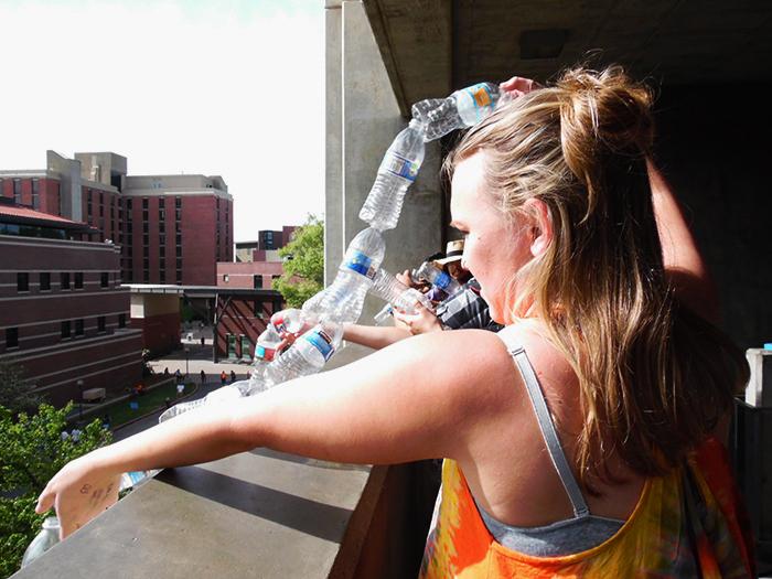Molly Marcussen lowering the bottles that will eventually hang from the third floor of Butte Hall. Photo credit: George Johnston