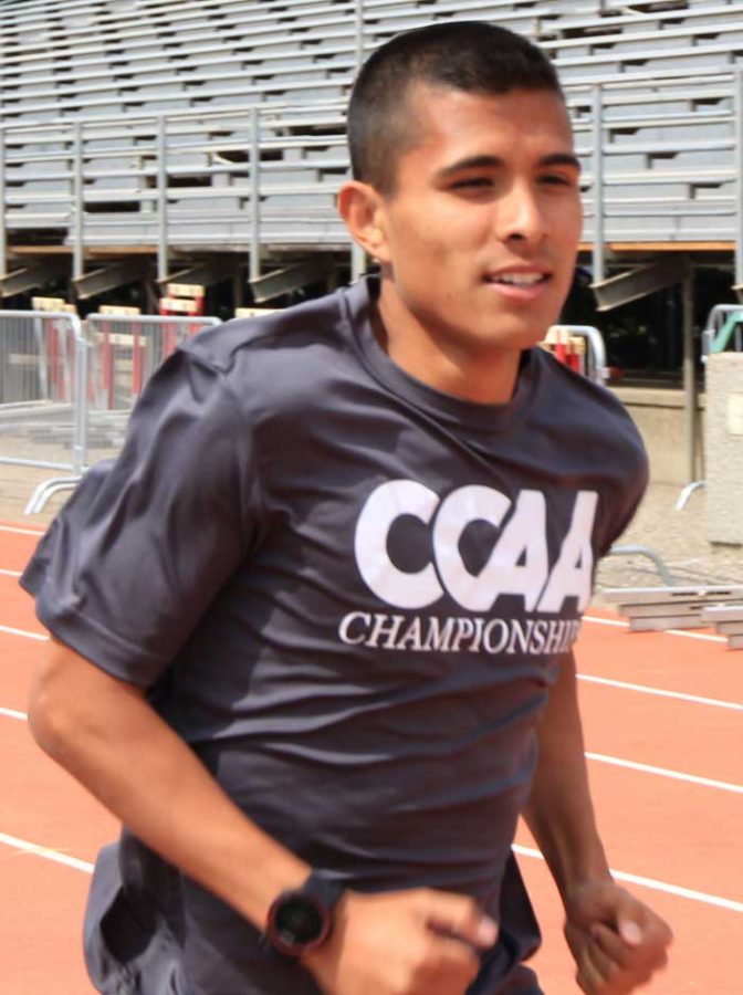 Junior+runner+Steven+Martinez+runs+around+the+track+during+practice.+Photo+credit%3A+Cam+Lesslie