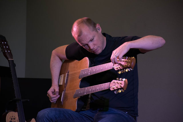 Ian Ethan Case tunes his 18-string acoustic guitar. Photo credit: Aurora Evans