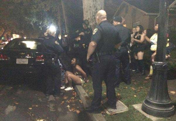 A woman handcuffed for public intoxication, Oct. 31, 2014. Photo credit: Lindsay Pincus