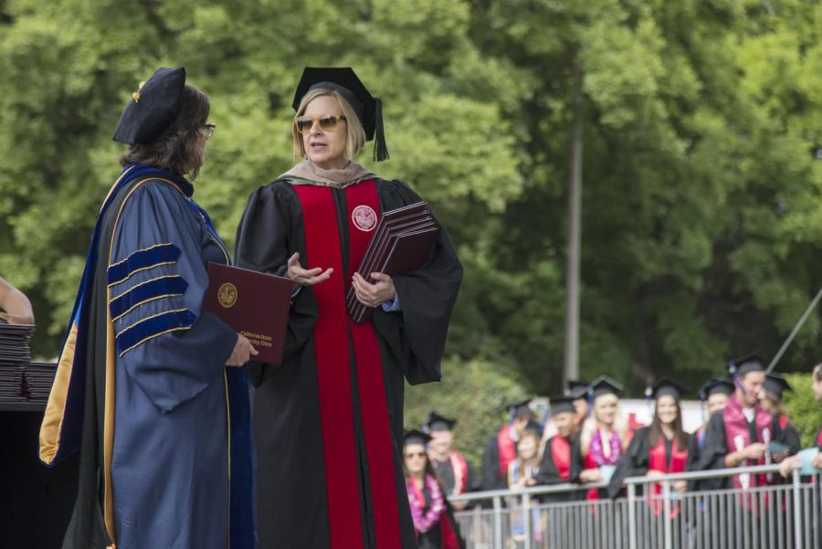 Susan Elrod (left) and Lori Hoffman (right) present diplomas to graduates during the Commencement ceremony for Colleges of Humanities And Fine Arts and Business at University Stadium on Sunday, May 17, 2015 in Chico, Calif. 