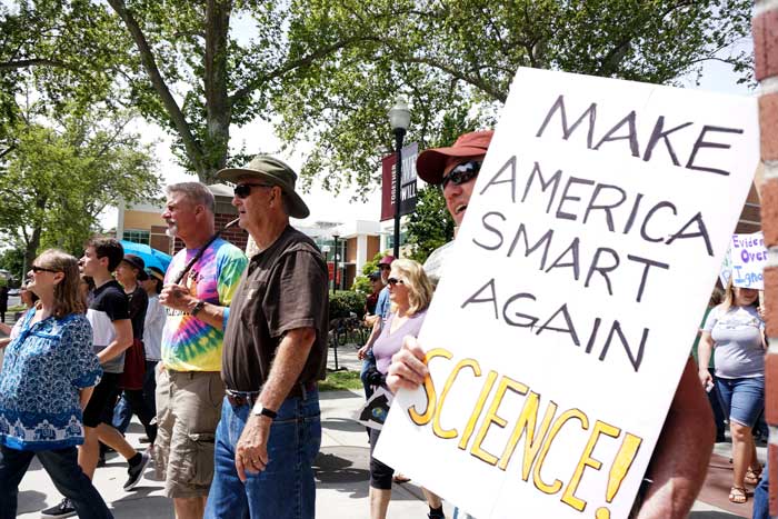 A marcher is seen chanting and holding his sign that reads: Make America Smart Again. Science! Photo credit: Floritzel Salvador