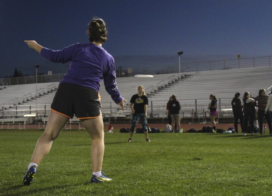 Annabelle Cole, a freshman on Chicos Womens Ultimate team flicking a disc to teammate Rose McDonough before a late-night practice at the University Stadium. Photo credit: Anne Chamberlain