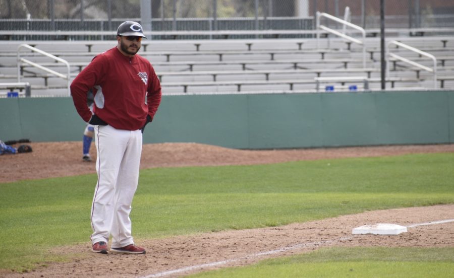 Third base coach Jose Garcia looks at one of his players on first base to give him a sign. Photo Credit: Alex Grant