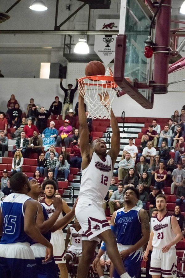 Junior forward, Marvin Timothy throws down a dunk for the Wildcats. Photo credit: Kate Angeles