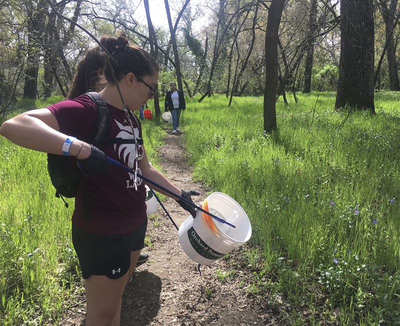 Janelle Bettencourt picks up trash in Lower Bidwell park with her lacrosse teammates. Photo credit: Lizzie Helmer