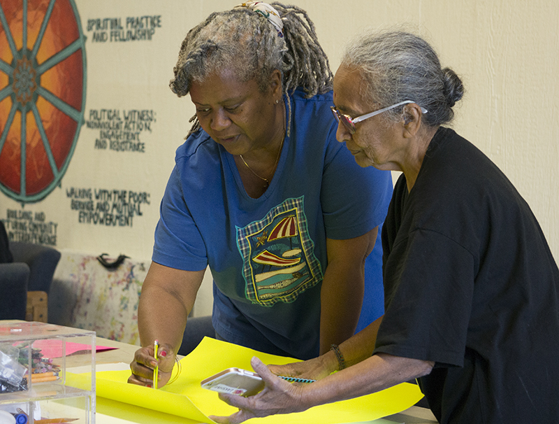 Volunteers Lakshmi and Frances Mann work together to create posters for the Martin Luther King remembrance walk. Photo credit: Carly Maxstone
