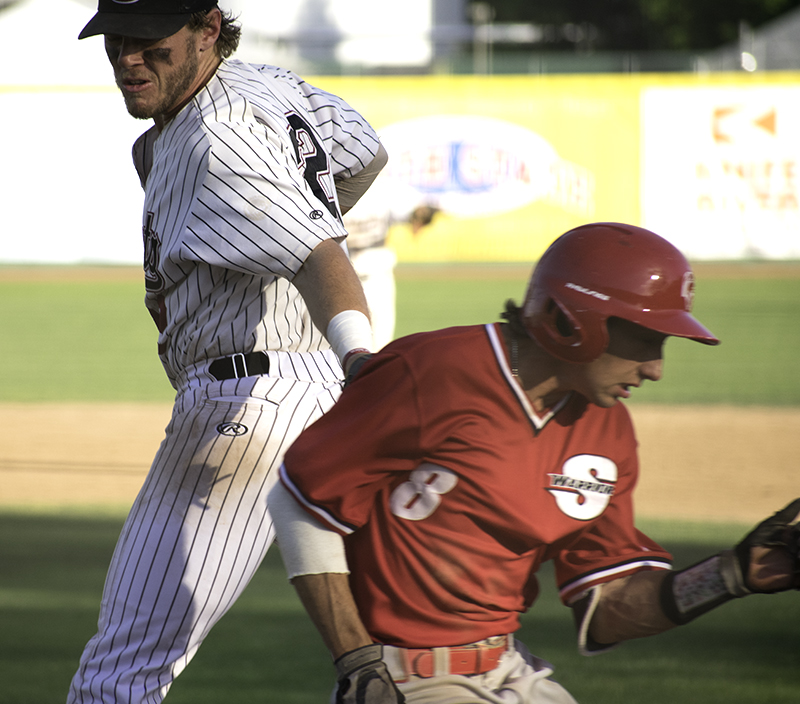 Chico State first basemanRJ Hassey tags out Stanislaus States John Holleran at first base after a wild throw during the second game played on May 4. Photo credit: Martin Chang