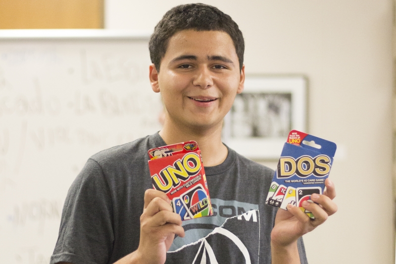 Christopher Hernandez holds up his prizes Sunday after becoming the first winner of the game Lotería at the Second Annual Welcome Week Game Night. Photo credit: Brian Luong