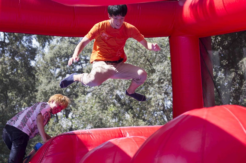 Tetta Ogawa jumps through the obstacle course while his friend Royeni Hasegawa watches him at Chico States Bidwell Bash Sunday.
