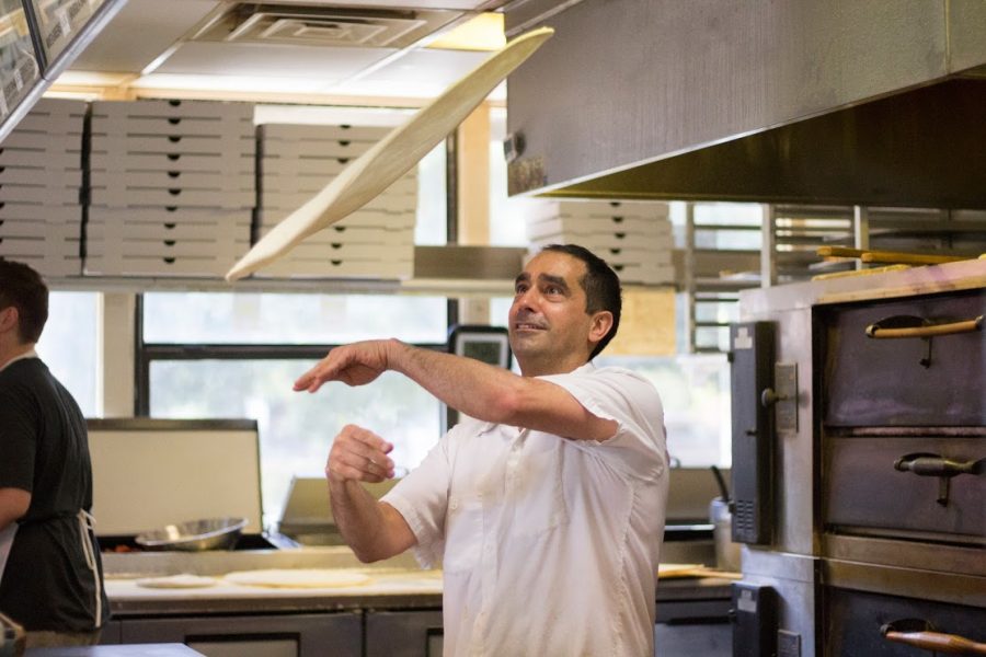 Enzo Perri tosses pizza dough to the desired form for Fridays dinner rush at Celestinos. Photo credit: Brian Luong