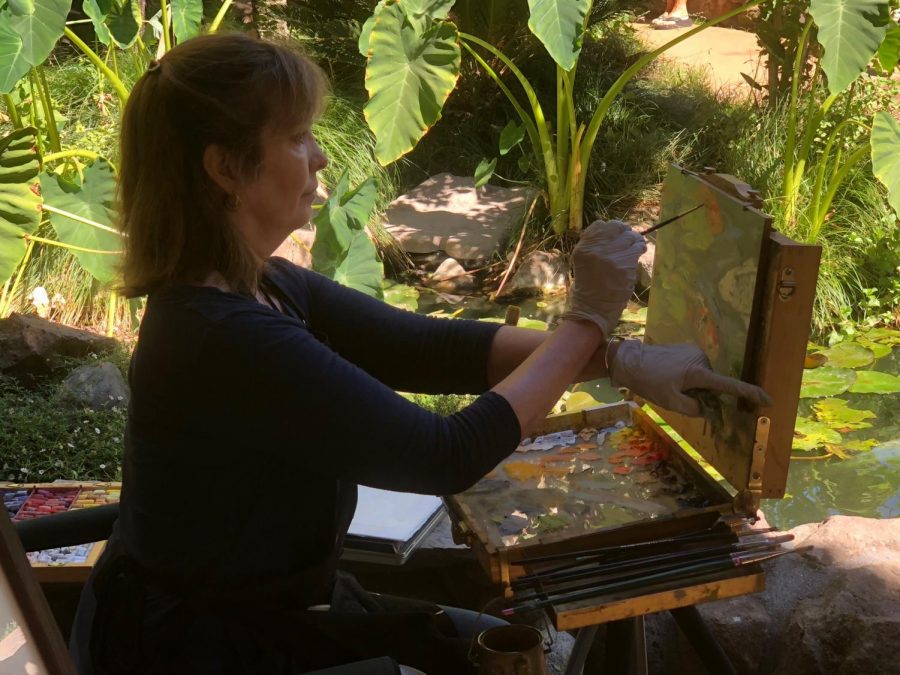 Janet Lombardi Blixt painting on a canvas during Chico Outdoor art festival Photo credit: Alex Coba