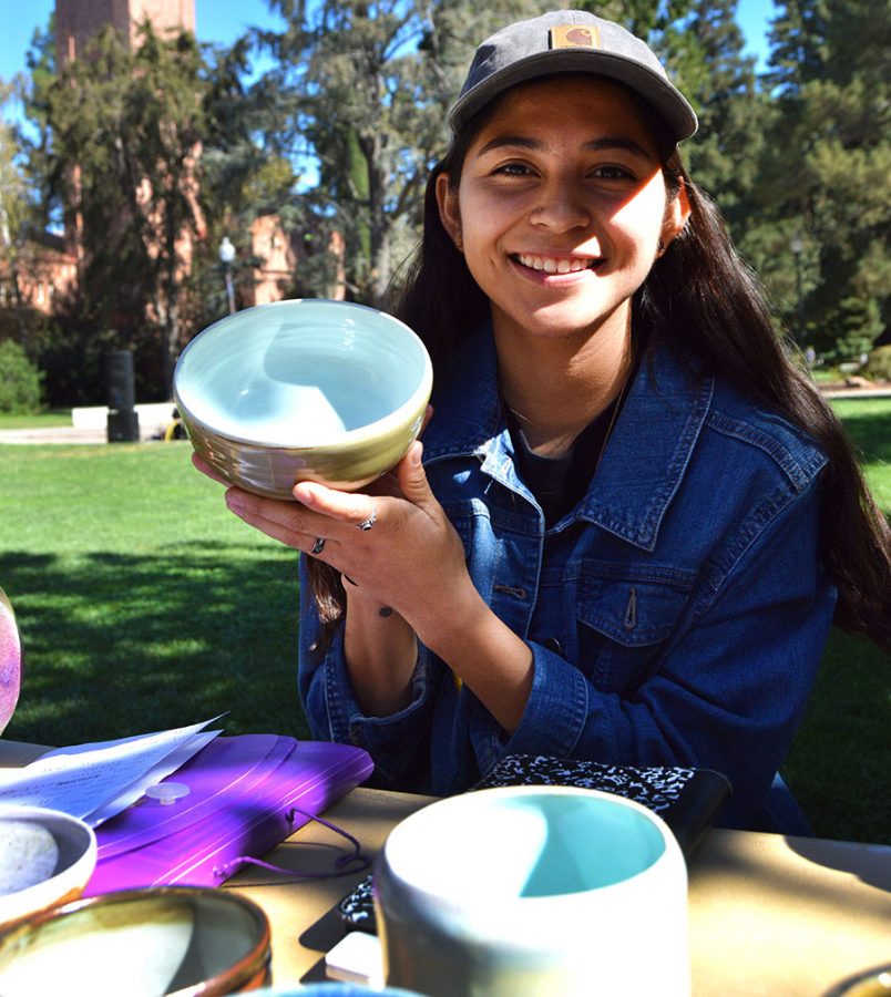 Child Development major Patty DeLeon shows off a ceramic piece she made during the pottery sale in front of Trinity Commons. Photo credit: Olyvia Simpson