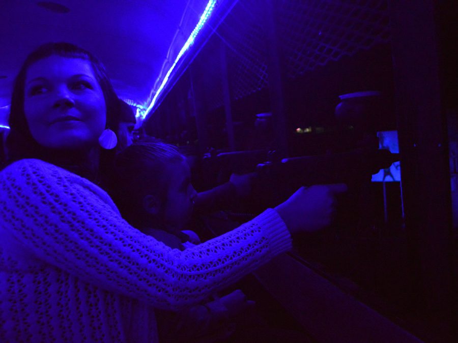 Stacy Lazzarino and her daughter are illuminated by the eerie blue light while shooting zombies at the Silver Dollar Fairgrounds Sunday night. Photo credit: Olyvia Simpson