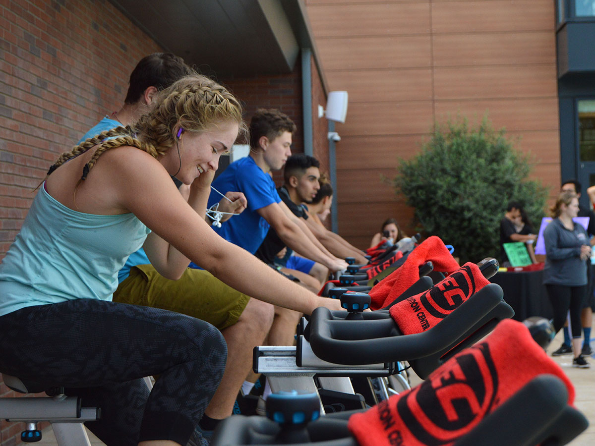 Ashley Brown adjusts her headphones during the biking portion of the Wrec's Tough Cat event on Friday. The event was a triathlon with swimming, biking and running. Photo credit: Olyvia Simpson