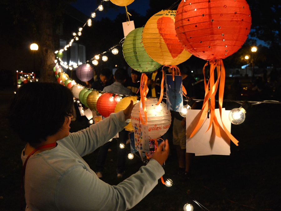 Marifer Martinez places the lantern she decorated to the lights string. Photo credit: Olyvia Simpson