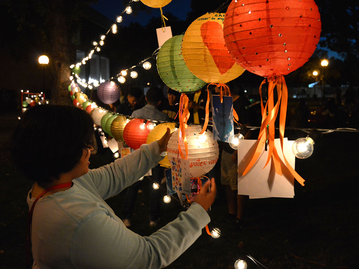 Marifer Martinez places the lantern she decorated to the lights string. Photo credit: Olyvia Simpson