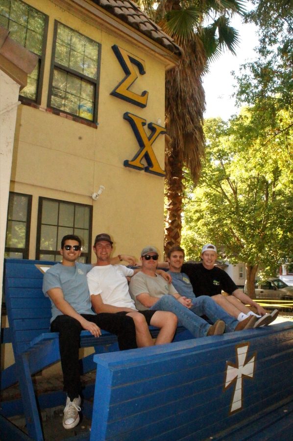 A group of Sigma Chi brothers sitting on the bench in front of the chapter house. Photo credit: Keelie Lewis