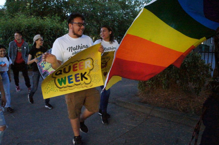 Several Pride Marchers with their queer week posters. Photo credit: Keelie Lewis
