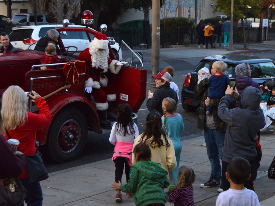 Children happily run up to greet Santa as he pulls up in a vintage firetruck to help light the Christmas tree in the downtown plaza. Photo credit: Olyvia Simpson