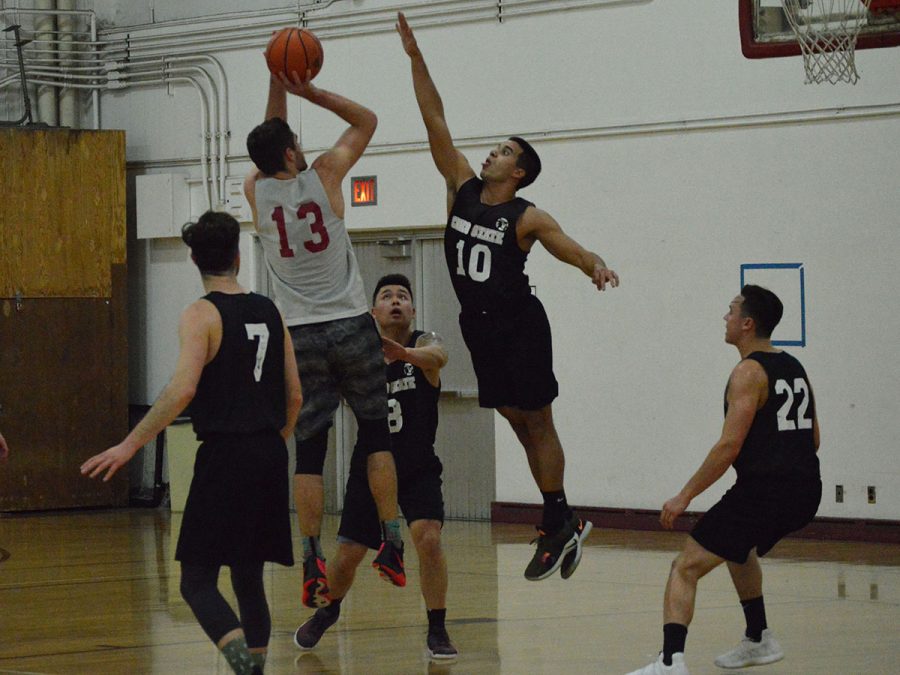 Andy Beronilla jumps up to block John Vega’s shot on the basket at Monday night’s practice on March 4, 2019. Photo credit: Olyvia Simpson