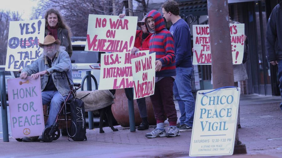 As the protest continues more of Chico Peace Vigils members show up. They grab a sign and stand on various parts of the sidewalk to show passing cars their signs, Saturday, Mar. 2, 2019, in Chico, CA. Photo credit: Melissa Herrera