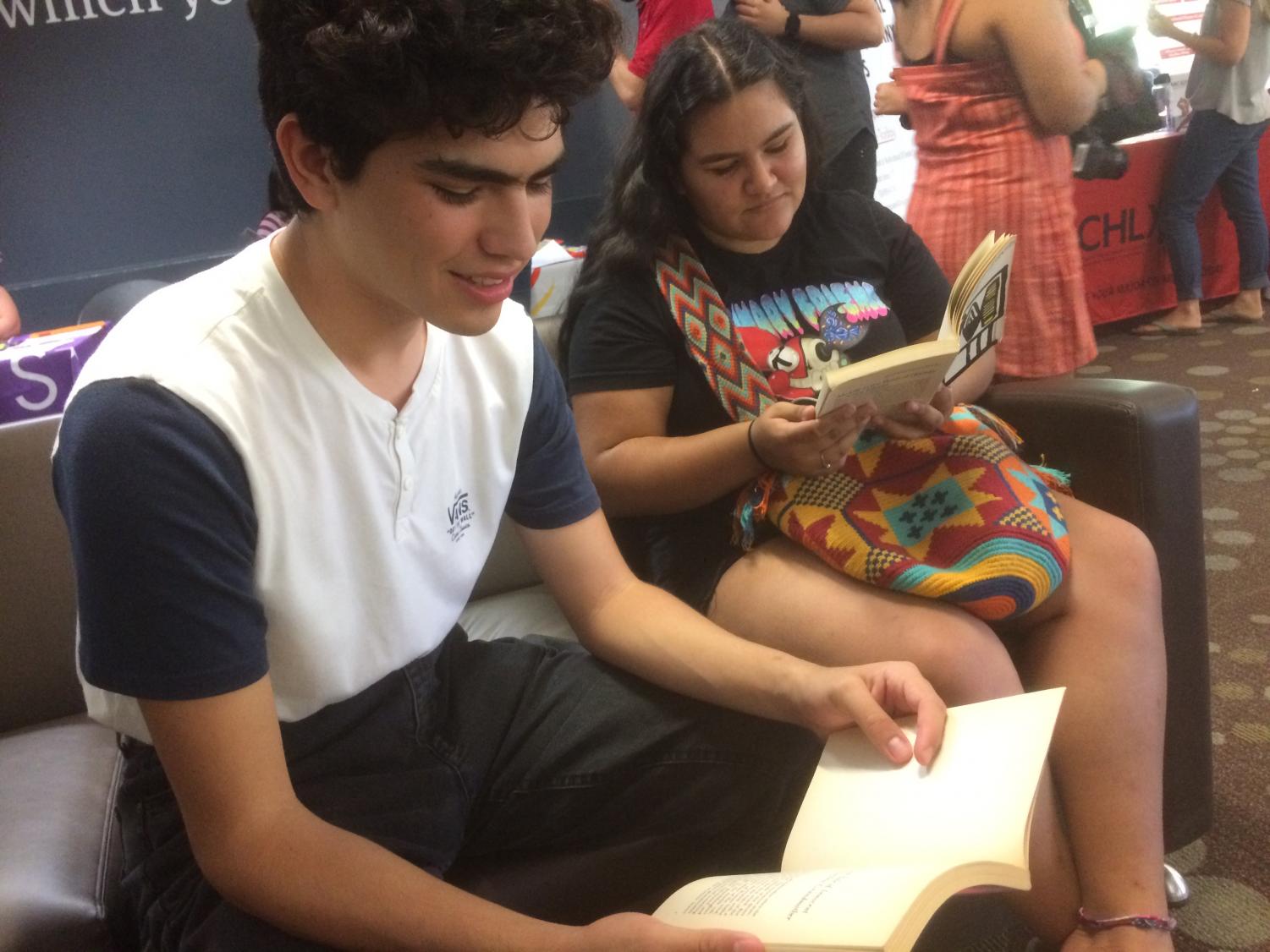 Attendees from the LGBTQ+ Welcome Reception browse some of the radical books from the book swap at the event. Photo credit: Emily Neria