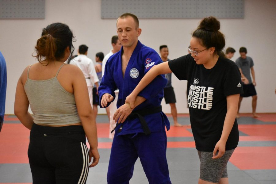 Instructor Austin Stahl teaches a breakaway technique to two students. Photo credit: Lucero Del Rayo-Nava