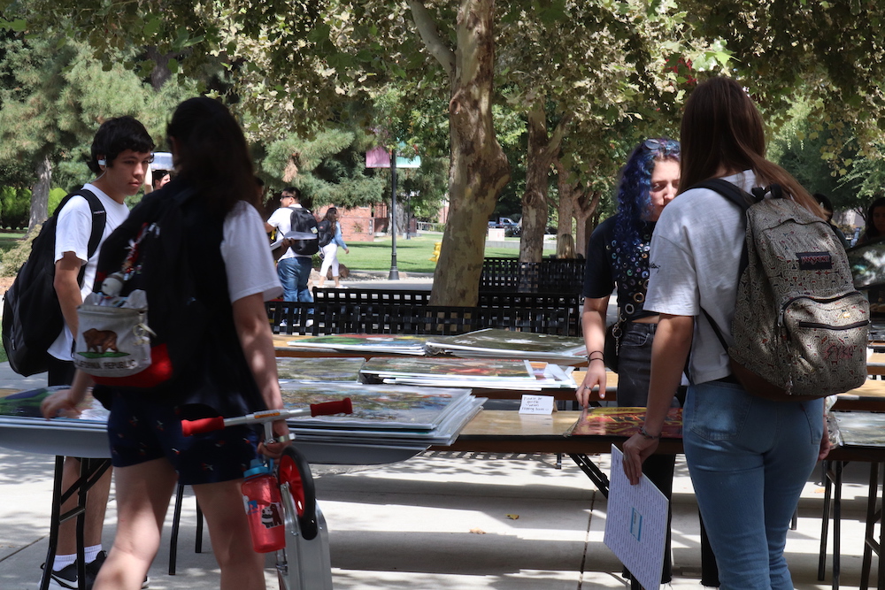 There were artistic posters on tables as freshmen sorted through the stacks to find the ones they liked the most. Photo credit: Melissa Herrera