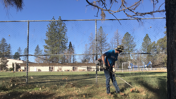 Charles Brooks mowing the grass in front of Paradise Adventist Academy for Make a Difference Day. Photo credit: Jessie Imhoff