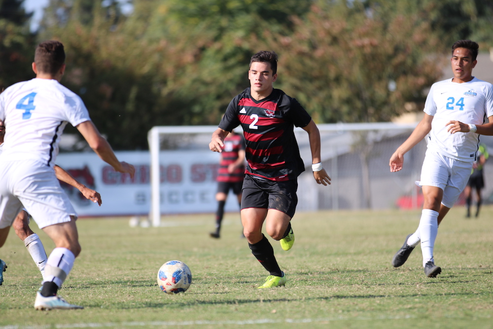 Mikey Hirsch defending the ball not letting Tony Di Donato (far left) and Sergio Gonzales (far right) get the ball. Photo credit: Hana Beaty
